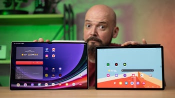 Person holding two Android tablets towards the camera, wondering which one to pick.