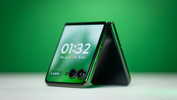 Motorola Razr Plus in Spring Green placed on a table against a blurred green background.
