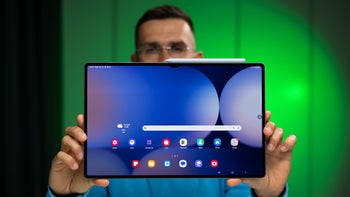 Image of a person holding up a Galaxy Tab S10 Ultra tablet showing the display